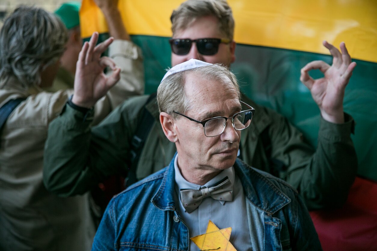 Demonstrator behind a counter-protester displays 'white power' hand gestures Demonstrator behind a counter-protester displays 'white power' hand gestures