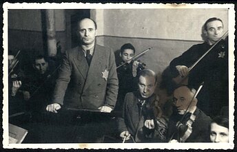 Kauno geto orkestro nariai. Už Michelio Hofmeklerio, Boriso Stupelio (jis po karo emigravo į Australiją) ir Šmajos Stupelio (jis žuvo Dachau) – trylikametis smuikininkas Yankale. Kauno geto orkestro nariai. Už Michelio Hofmeklerio, Boriso Stupelio (jis po karo emigravo į Australiją) ir Šmajos Stupelio (jis žuvo Dachau) – trylikametis smuikininkas Yankale.