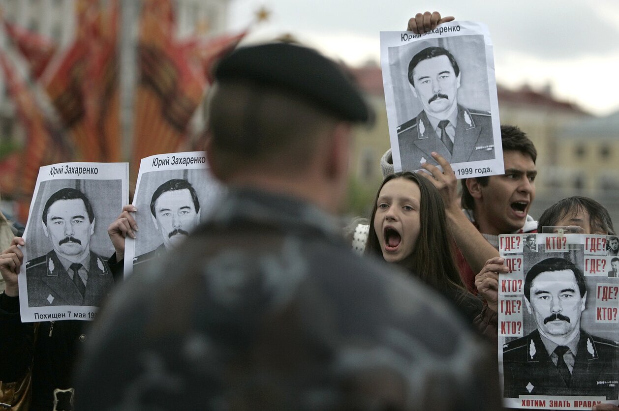 Opposition supporters hold images of Gen. Yuri Zakharenko on an anniversary of his mysterious disappearance