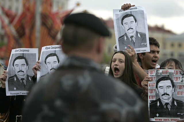 Opposition supporters hold images of Gen. Yuri Zakharenko on an anniversary of his mysterious disappearance