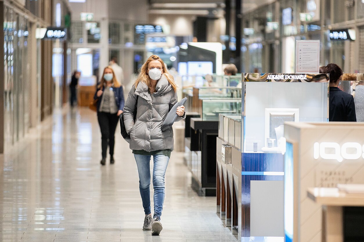 People wear facemasks in a shopping mall People wear facemasks in a shopping mall