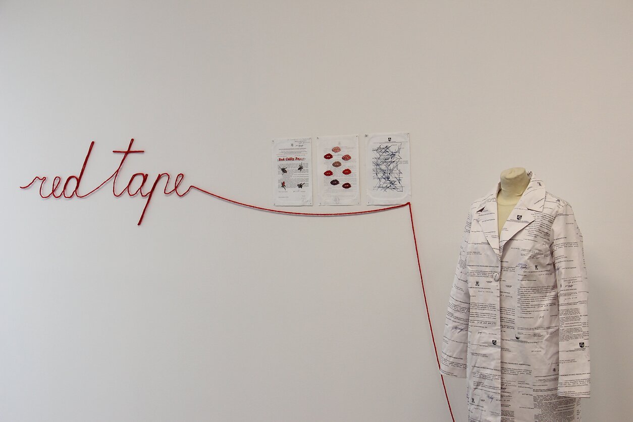 Inetos Armanavičiūtės fotografija, Eglės Gandos Bogdanienės instaliacija „Red tape“ (2013) parodoje „M/A\G/M\A. Kūnas ir žodžiai Italijos ir Lietuvos moterų mene nuo 1965 metų iki šių dienų“ Nacionalinėje dailės galerijoje. Vilnius, 2017 m.