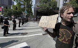 „QAnon“ šalininkas per teisės į ginklą šalininkų protestą Seatle, 2018 m.