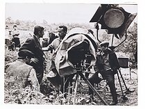 Vaidybinio filmo „Niekas nenorėjo mirti“ (rež. Vytautas Žalakevičius, Lietuvos kino studija, 1965 m.) filmavimas.  Pirmame plane: Pirmas iš kairės aktorius Bronius Babkauskas (iš nugaros).  Antras iš kairės aktorius Bruno Oja.  Trečias iš kairės režisierius Vytautas Žalakevičius.  Ketvirtas iš kairės operatorius Jonas Gricius.