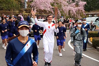 Gediminas Varvuolis carrying the Olympic torch during the delayed 2020 Summer Olympics, held in 2021 in Tokyo.