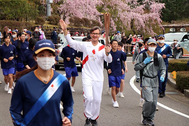 Gediminas Varvuolis carrying the Olympic torch during the delayed 2020 Summer Olympics, held in 2021 in Tokyo.