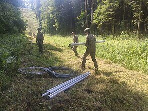 Lietuvos kariai pasienyje su Baltarusija pradėjo tiesti spygliuotos vielos užtvarą Lietuvos kariai pasienyje su Baltarusija pradėjo tiesti spygliuotos vielos užtvarą