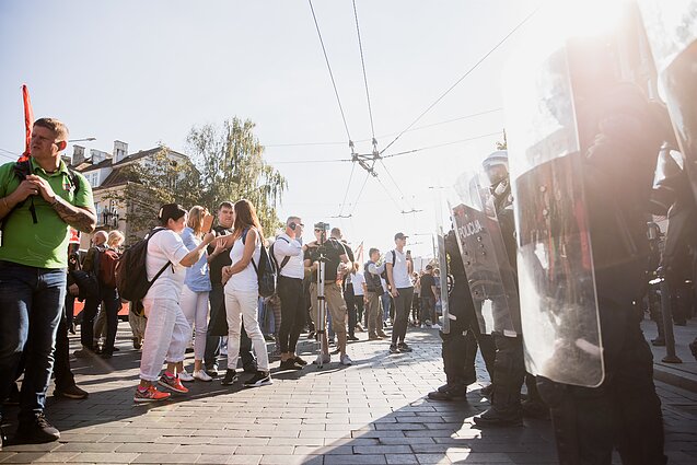 Po mitingo minia žingsniuoja link Seimo, riaušių malšinimo pareigūnai ir policija juos stabdo greta Lukiškių aikštės
