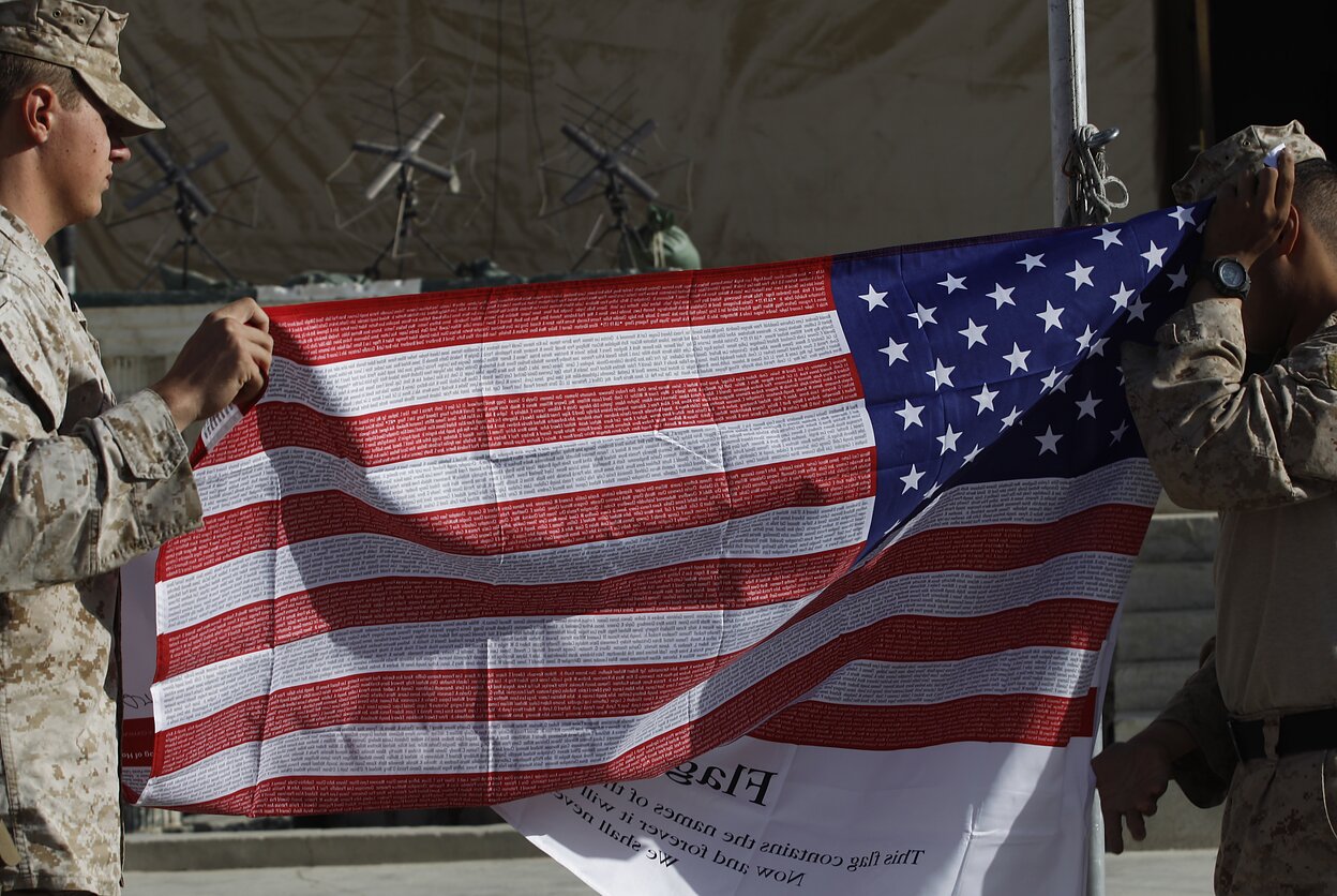 JAV kariai Afganistane laiko vėliavą, ant kurios užrašyti per Rugsėjo 11-osios išpuolius žuvusiųjų vardai