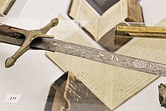 Parodoje ir rankraščių turinį atliepiantys eksponatai. Kardas su geležtėje užrašyta apsaugine formule Parodoje ir rankraščių turinį atliepiantys eksponatai. Kardas su geležtėje užrašyta apsaugine formule