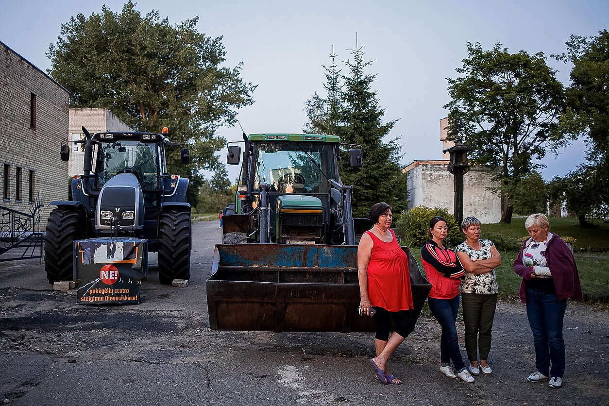 Vidaus reikalų ministerijai pranešus, kad Dieveniškėse ketinama apgyvendinti dalį neteisėtai sieną kirtusių migrantų, sukilo vietos gyventojai. Prie migrantams atrinkto pastato jie budėjo keletą dienų, net ir naktimis, siekdami užkirsti kelią patalpų paruošimo apgyvendinimui ir aptvėrimo darbams. 
