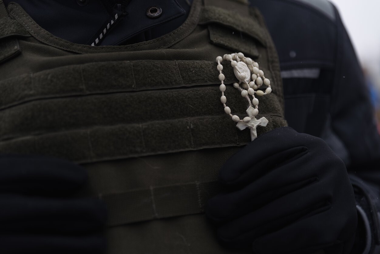 A rosary attached to the vest of a veteran of the war in Donbass