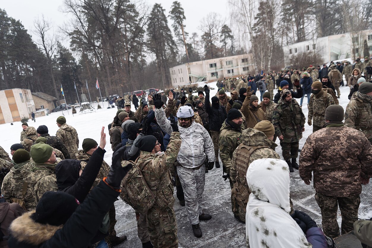 People raise their hand to say that they would like to receive one of the limited number of weapons available for training