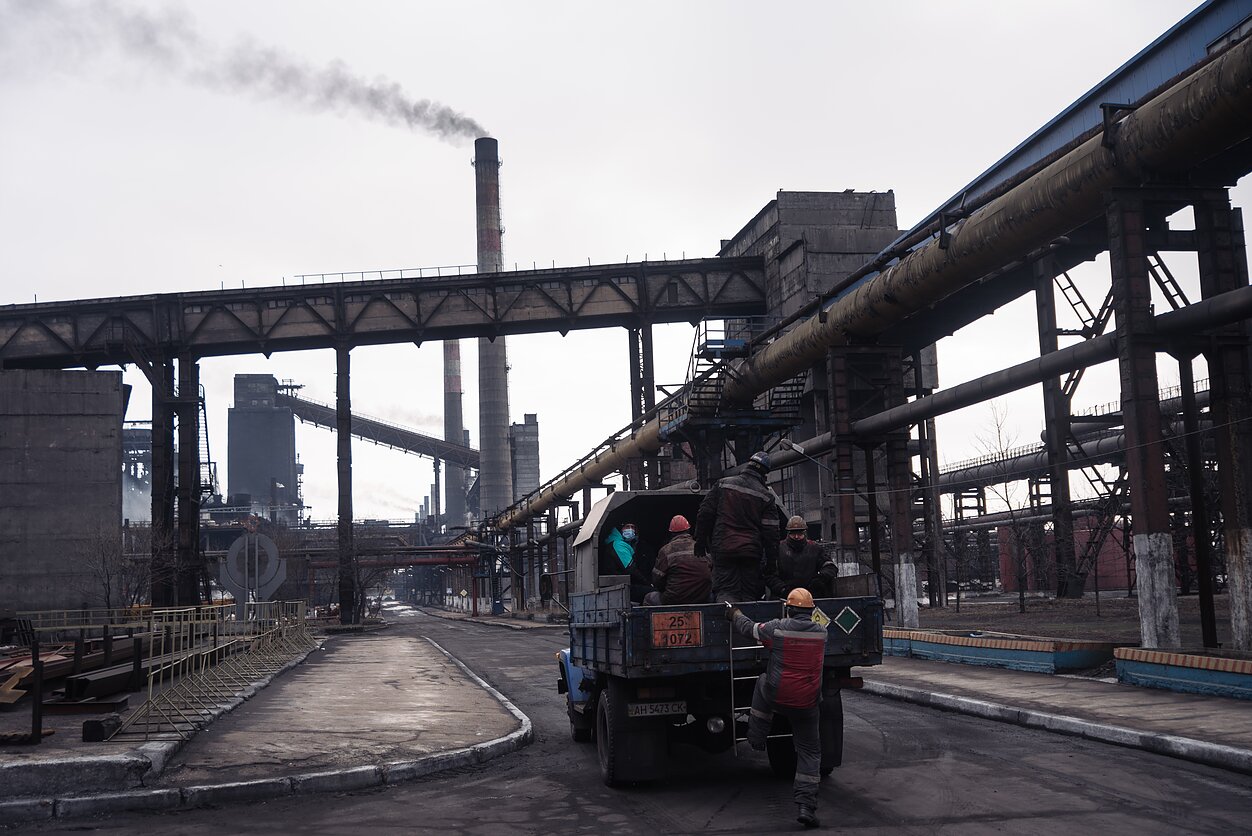 Už kelių šimtų kilometrų nuo Kijevo esantis kraštovaizdis pamažu pildosi pramoninio apleistumo ženklais, persipynusiais su monstriškomis metalo supirktuvėmis ir gamyklomis. Kokso gamykla tebėra Avdijivkos, pastatytos kaip pramoninis Donecko priemiestis, kurį dabar kontroliuoja Rusijos vadovaujami separatistai, identiteto pagrindas.