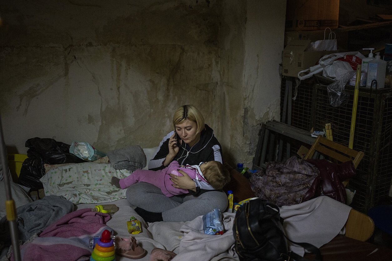 Ukrainietė su vaiku slepiasi slėptuvėje Kyjive per Rusijos atakas