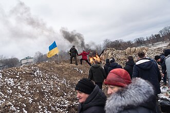 Eilė mesti Molotovo kokteilius driekiasi keliasdešimt metrų