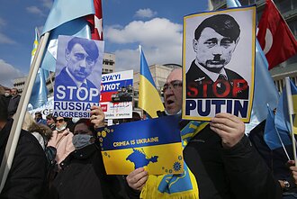 На проходящих по всему миру акциях протеста Владимира Путина часто уподобляют Адольфу Гитлеру