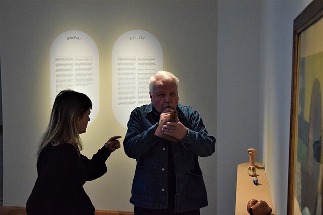 Menotyrininkas Viktoras Liutkus pučia Antano Mončio švilpį. Greta – skulptoriaus dukra Sabina Moncys