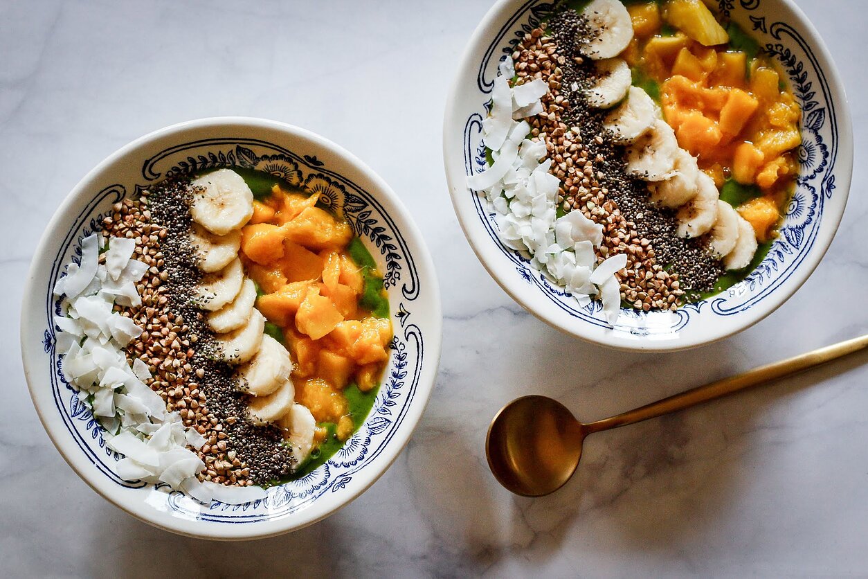 Pusrytinis žalio kokteilio dubenėlis su mangais ir daigintų grikių traškučiais