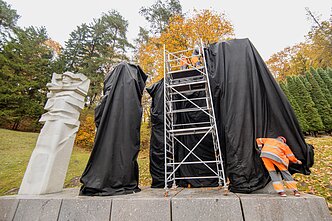 Antakalnio kapinėse juodais audeklais dengiami paminklai sovietų kariams