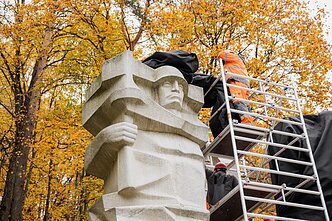 Antakalnio kapinėse juodais audeklais dengiami paminklai sovietų kariams