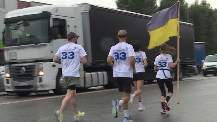 Įkvepianti akcija Ukrainos narystei NATO palaikyti: ukrainiečiai negaili padrąsinimų iš rankų vėliavos nepaleidžiantiems bėgikams