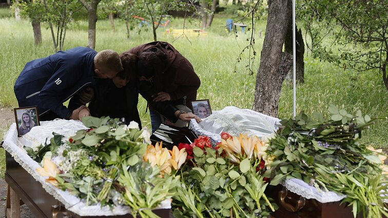 Kramatorskui atsisveikinus su nužudytomis 14 metų dvynukėmis, Rusija teigia miesto picerijai smūgiavusi tyčia