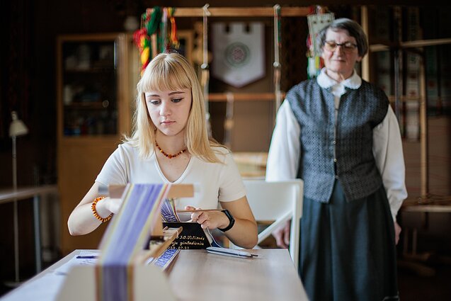 Panevėžio rajono juostų audėja O. Vilienė tautinę tradiciją perduoda ir savo mokiniams. 