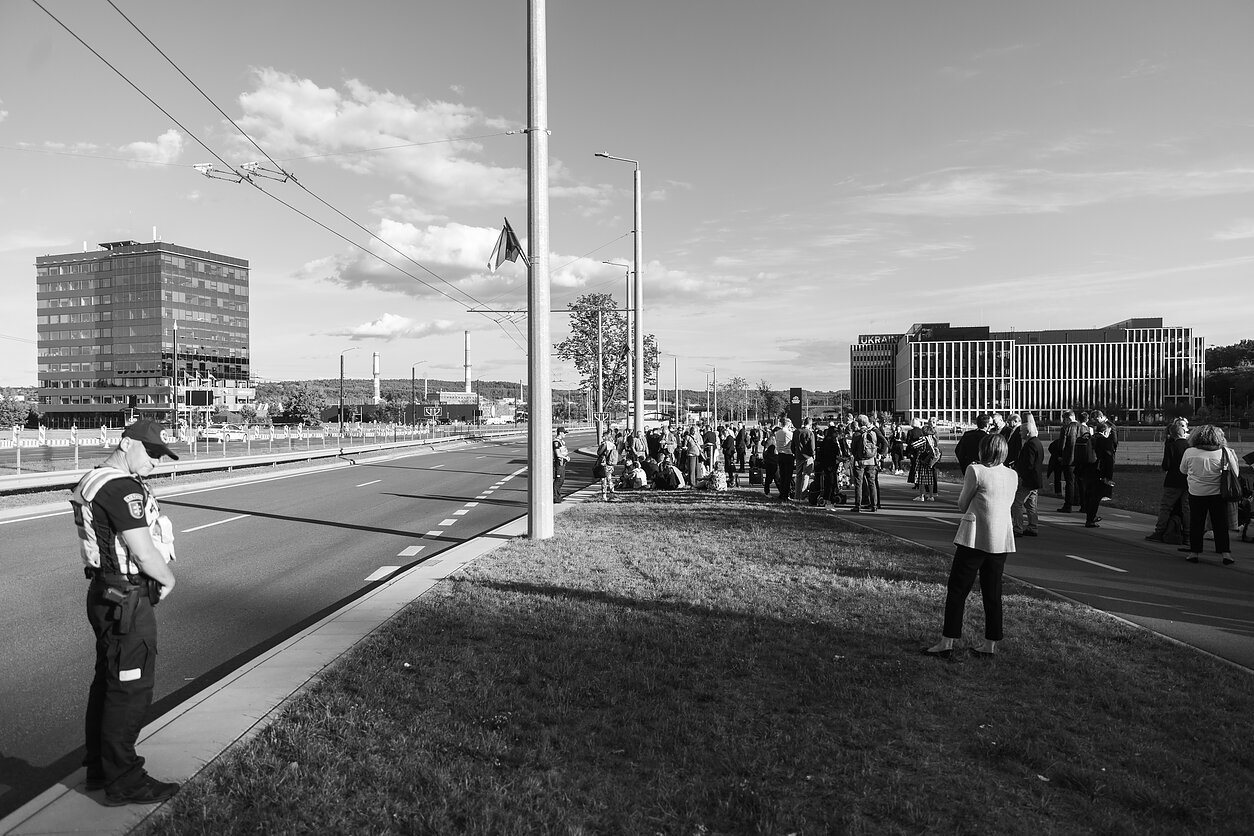 Šimtai žurnalistų laukia maršrutinių autobusų į „Litexpo“ centrą ir iš jo, o policija budi uždarytoje gatvėje.