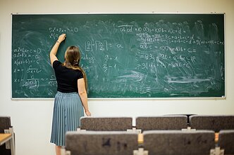 Ieva Kilė auditorijoje rašo matematines lygtis