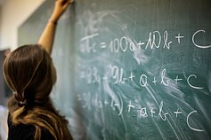Ieva Kilė auditorijoje rašo matematines lygtis