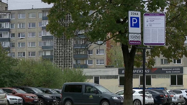 Žinios. Karoliniškėse apmokestinus aikštelę šalia daugiabučių, gyventojai kovoja dėl vietos automobiliui: nuleidžia ir ratus