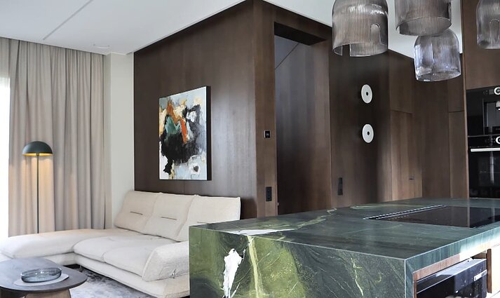 Avokado atspalvio akcentų prisotintame interjere – erdves išryškinantys originalūs šviestuvai