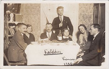 Fotoatvirukas. Grupinė nuotrauka. Bohemiškai atrodančių asmenų (trijų moterų ir keturių vyrų) kompanija prie kuklaus Kalėdų stalo. Kaunas, 1938 m.