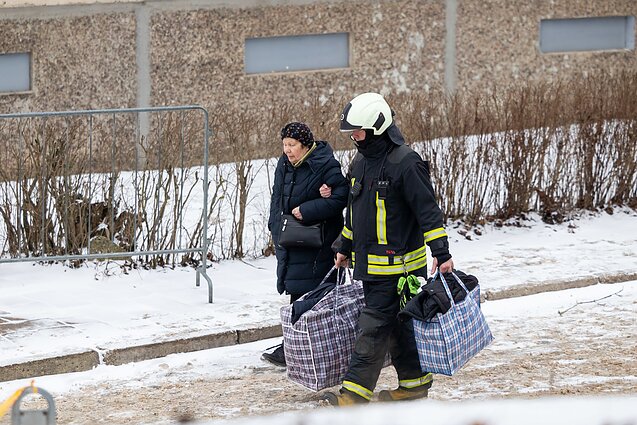 Gyventojai iš gaisro suniokoto Viršuliškių daugiabučio nešasi daiktus