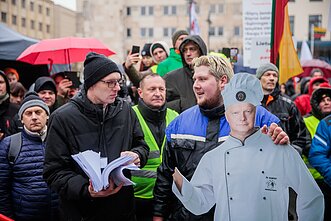 Sceną palikusį ministrą protesto dalyvis čiupo už pakarpos 