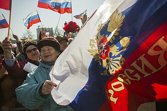 Žmonės su Rusijos vėliavomis, susirinkę žiūrėti Putino kalbos; Krymas 2014 m.
