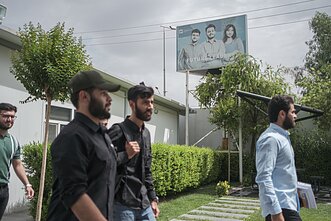 University students walk past a faded billboard, “Future leaders”. University students walk past a faded billboard, “Future leaders”.