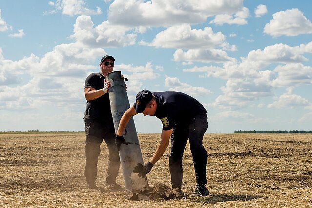 A Ukrainian bomb disposal team dismantle and remove the remains of a Russian rocket which carried cluster munitions