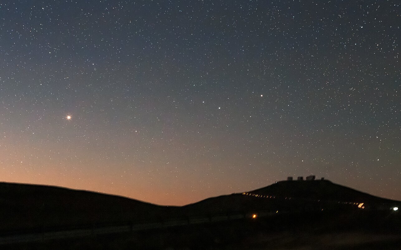 Rami naktis Čilės Atakamos dykumoje. Labiausiai į akis krinta ryški rausva dėmė dangaus centre kairėje pusėje – Marsas.