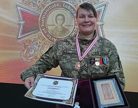 Seržantė džiaugiasi gautu apdovanojimu