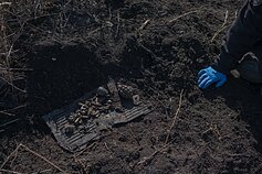Žemėje randami kaulų fragmentai ir nesprogusios granatos bei kita amunicija.