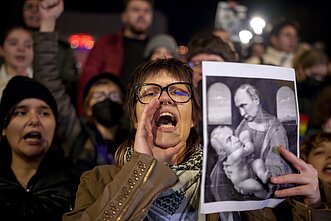 Protestas prieš Caliną Georgescu, kurį fotomontaže ant rankų laiko Vladimiras Putinas