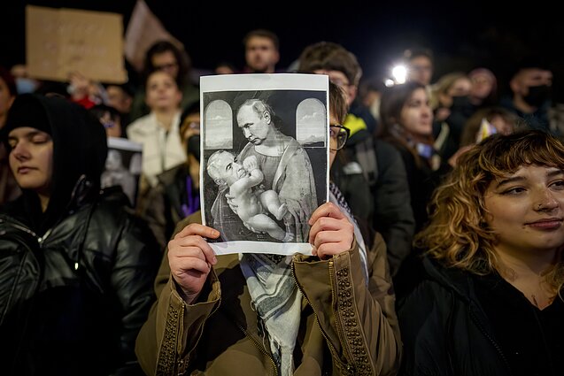 Protestas prieš Caliną Georgescu, kurį fotomontaže ant rankų laiko Vladimiras Putinas