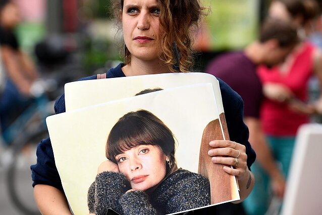 A woman holds an image of Marie Trintignant at a protest in Paris