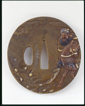 Yanagawa Naomasa (1692–1757 m.) Cuba su karo dievu Kaniu Japonija, 18 a. I pusė Sentoku (vario lydinys), bronzos ir aukso inkrustacija, reljefinis dekoras 7,3 × 6,8 cm Nacionalinis Bohdano ir Varvaros Chanenkų dailės muziejus