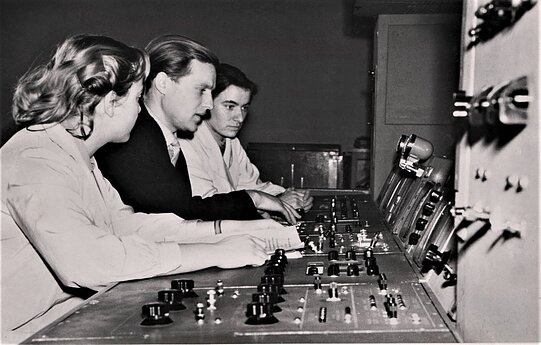 1957 m. balandžio 30 d. transliuota pirmoji televizijos programa. Prie pulto (iš kairės): Janina Grivickienė, transliacijos režisieriaus asistentas Anupras Lauciūnas ir inžinierė Marija Gaidamavičiūtė. 