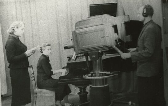 TV diktorė Laima Šalčiūtė, pianistė Halina Znaidzilauskaitė, operatorius Jonas Šemetas studijoje filmavimo metu. 1957 m.  