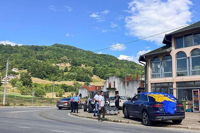 Serbijos Respublikos policija prie degalinės stebi keliautojus į Srebrenicą. Gal dėl to, kad nėra lengva įrengti memorialus karo aukoms, sukaktys dažnai minimos dviratininkų, baikerių, bėgikų žygiais