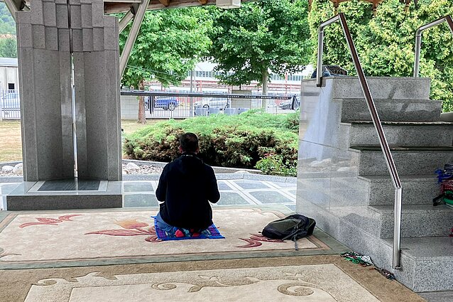 Apžiūrėjęs Srebrenicos memorialą, turistas atsiklaupia pasimelsti